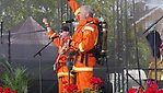 Två män i branduniform på en scen och sjunger.